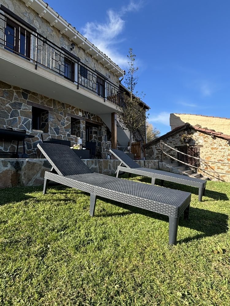 Garden with sun loungers and the stone house behind