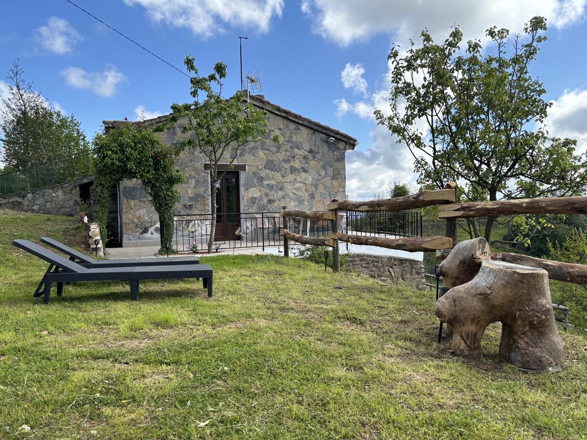 Stone house with garden, sun loungers and wooden fence