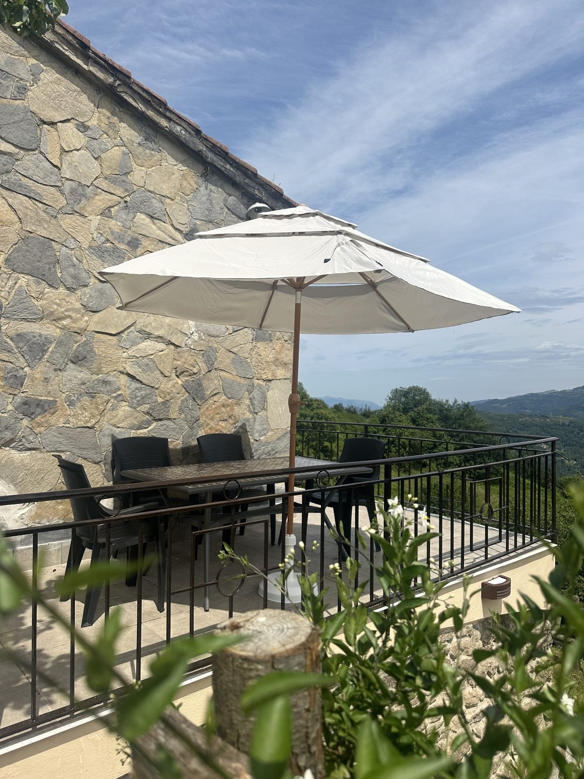 Terrace with a parasol, a table and views over the valley