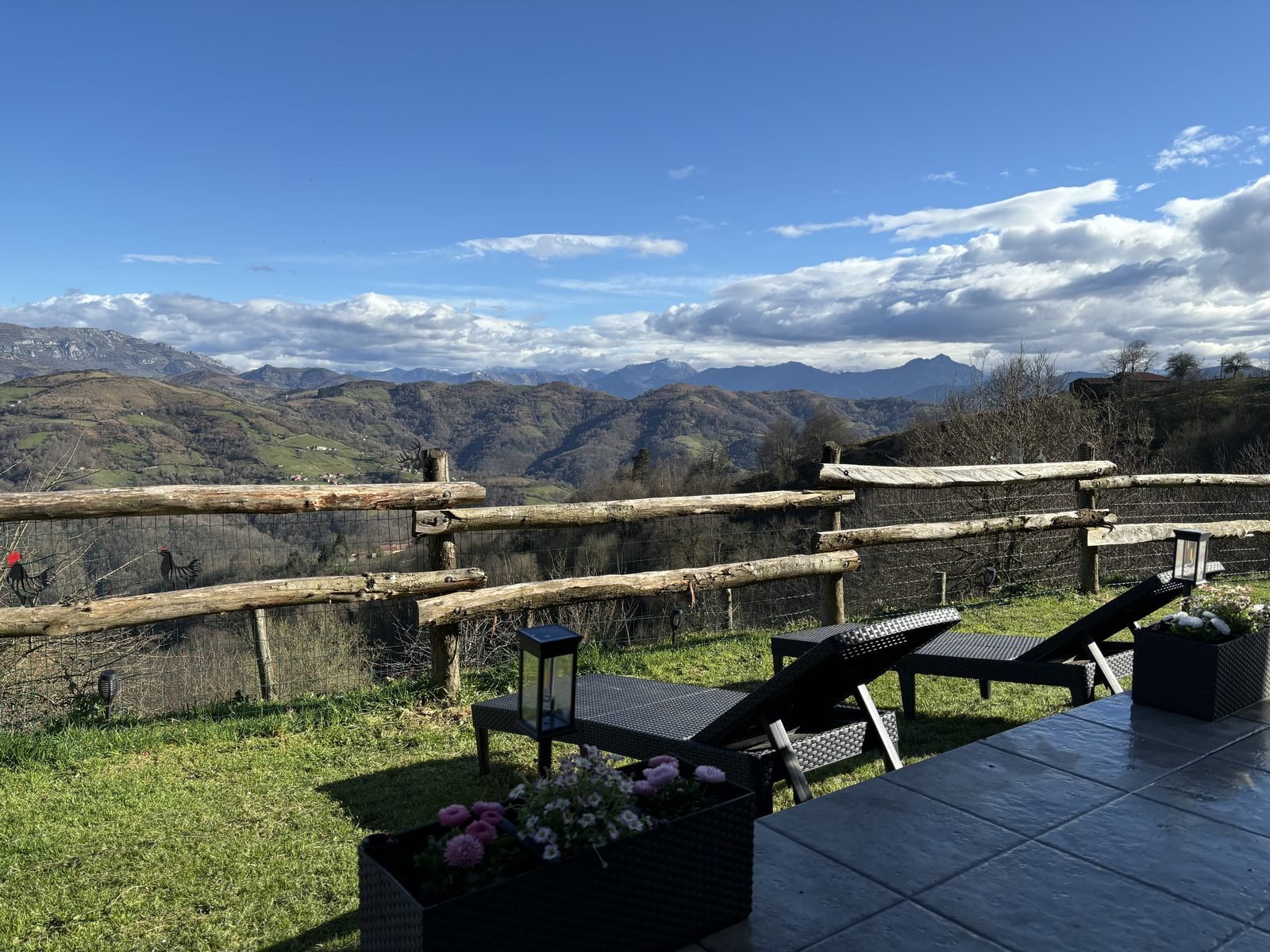 Sun loungers and flowers facing the mountains