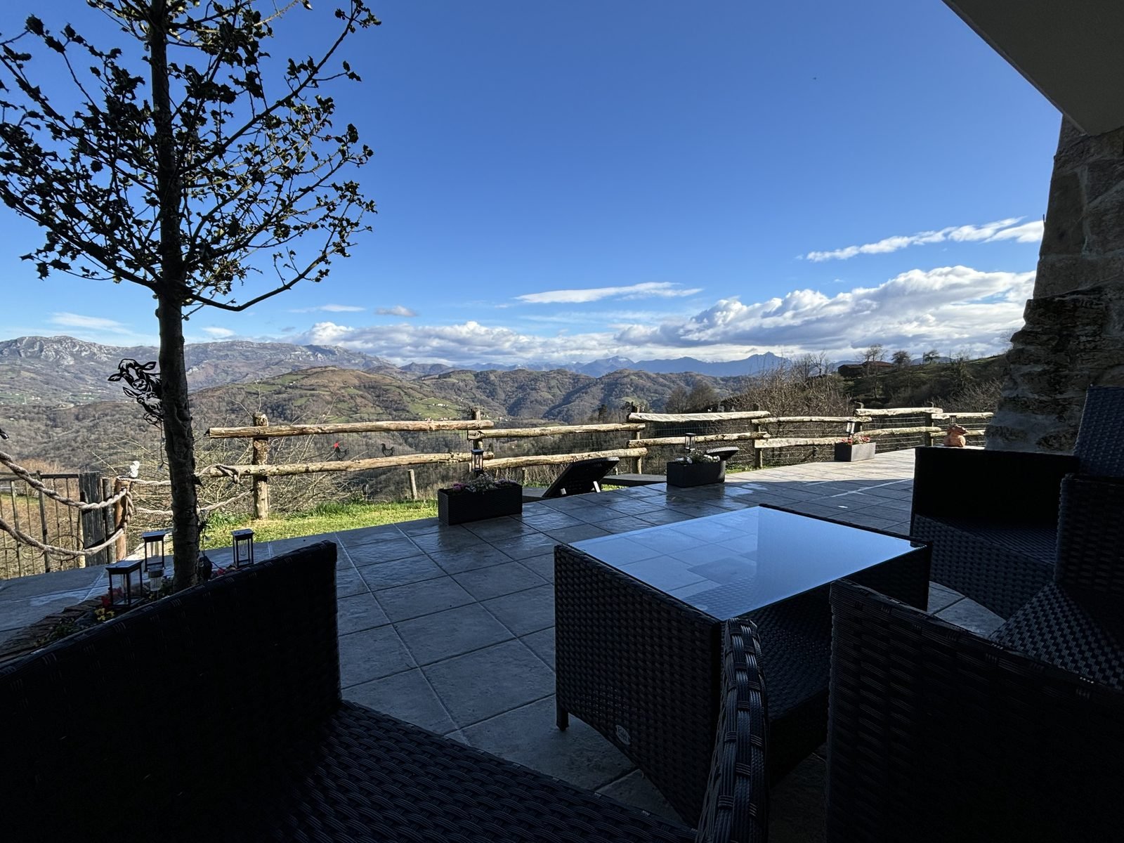 Outdoor sofas and a glass table looking out to the mountains