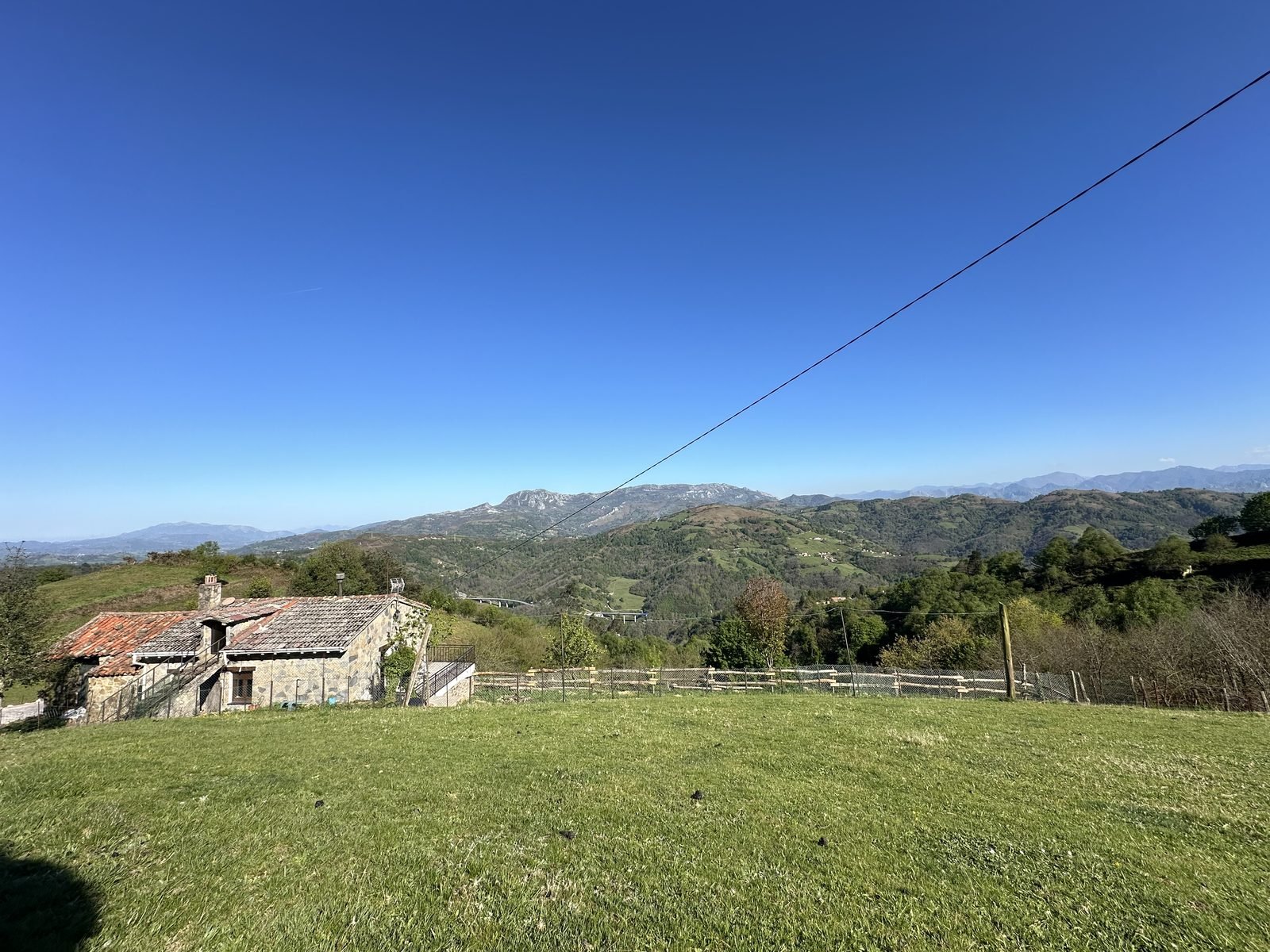 Green meadow and the mountain range under a blue sky